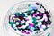 colored sequins in a plastic jar close-up