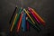 Colored sharpened pencils lie on the dark surface