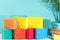 Colored sponges for washing dishes and cleaning in a sunny room with palm tree and long shadows. The concept of cleanliness in the