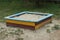 Colored square wooden sandbox with white sand