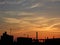 Colored sunset sky above dark industrial silhouettes