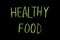 Colored text `healthy food` written  on chalkboard
