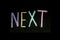 Colored text `next` written  on chalkboard