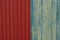 Colored texture of red metal wall and frayed wooden boards