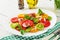 Colored tomato salad with onion and basil pesto.