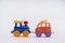 Colored toy cars collided in an accident on a white background Crash on a toy road