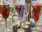 Colored wine glasses on a shelf in a store. Glassware for drinks made of transparent glass. Crystal glasses for the holiday