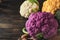 Colorfu cauliflower. Various sort of cauliflower on old wooden background. Purple, yellow, white and green color cabbages. Broccol