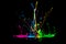 Colorful abstract paint splashing on audio speaker isolated on black background