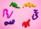 Colorful antistress children toys on pink paper background with copy space