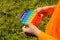 Colorful antistress sensory toy fidget push pop it in kid& x27;s hands. Pop it toy. Girl plays outside.