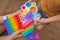 Colorful antistress sensory toy fidget push pop it in toddler& x27;s hands. Antistress trendy pop it toy. Rainbow sensory