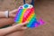 Colorful antistress sensory toy fidget push pop it in toddler& x27;s hands. Antistress trendy pop it toy. Rainbow sensory