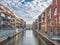 Colorful apartments on the both sides of canal in Amsterdam with boats and blue sky