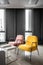 Colorful armchair in minimal modern style with windows and black metal background in natural light setting / interior / copy space
