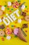 Colorful array of different childs sweets and treats on yellow background. Candies with jelly, chocolate, ice cream, lollipops,