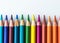 Colorful array of sharpened pencils lined up against a white background