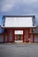 Colorful Asian building with distinct white and red roofs, featuring elegant pillars