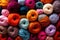 Colorful assorted variety of balls of thick knitting yarn, background texture