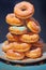 A colorful assortment of donuts arranged in a vertical stack, with sprinkles and glaze on it