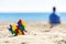 Colorful autism awareness heart on the sand and back view to silhouette of the child sitting on the beach and looking to