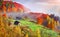 Colorful autumn landscape in the mountain village. Foggy morning