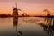 Colorful autumn scene in the famous Kinderdijk canals with windmills. Sunset in Dutch village Kinderdijk, Netherlands, Europe.