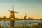 Colorful autumn scene in the famous Kinderdijk canals with windmills. Sunset in Dutch village Kinderdijk, Netherlands, Europe.