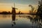 Colorful autumn scene in the famous Kinderdijk canals with windmills. Sunset in Dutch village Kinderdijk, Netherlands, Europe.