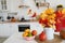 Colorful autumn still-life on a kitchen table. Pumpkin, bouquet of maple leaves and apples