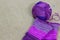Colorful ball of wool and piece of woven winter garment with crochet needle or hook against light background. copy space