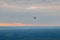 Colorful balloon high above the ground in the sky at sunset in fog