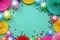 Colorful balloons and paper flowers on blue table top view. Festive or party background. Flat lay style. Copy space for text. Birt