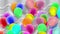 Colorful balloons swaying with the wind. The background is streaked with white fluffy fabric arranged in full space.