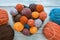 Colorful balls of wool in heart shaped plate, skeins of wool and knitting needles on rustic table. Hobbies and knitting concepts