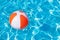 Colorful beach ball floating in pool