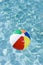 Colorful beach ball floating in swimming pool