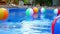 Colorful beach balls floating in pool
