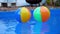 Colorful beach balls floating in pool in slow motion