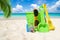 Colorful beach toys under palm frond