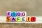 Colorful bead with letter in word food safety on wood background