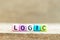 Colorful bead with letter in word logic on wood background