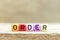 Colorful bead with letter in word order on wood background