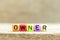 Colorful bead with letter in word owner on wood background