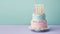 Colorful birthday cake in pastel colors with birthday candles and turquoise background