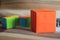 Colorful blank origami paper boxes. One big box in orange color and small box in blur background. Think out of the box concept.