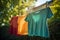 Colorful blank t-shirt hanging in back yard. Clothes waste and fast fashion concept.
