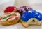 Colorful blue with bite, red, brown and stripes donuts with white background