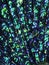 Colorful blue and green mixed round iridescent sequins, beads on knitting fabric for holiday, festive beautiful colorful