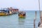 Colorful boat coming to pier of Koh Rong island, Cambodia. Sunny marine travel in tropical island.